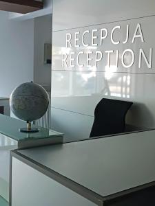 a white table with a vase on top of it at Aparthotel Strefa Budget in Tychy
