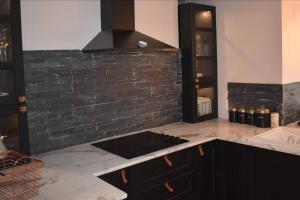a kitchen with a counter top and a black brick wall at Llansteffan 2-Bed Cottage Sleeps 4 Dog Ok in Carmarthen