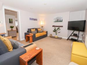 a living room with a couch and a tv at 4 Lynton Cottages in Hull
