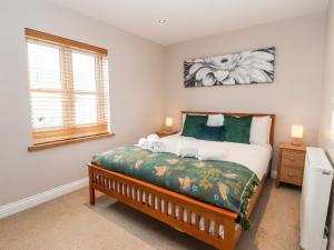 a bedroom with a bed with green and white at 4 Lynton Cottages in Hull
