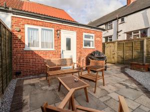 a patio with chairs and tables and a building at 4 Lynton Cottages in Hull