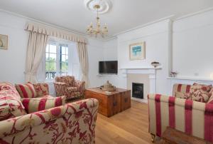 a living room with two couches and a tv at Cliff Cottage in Brixham