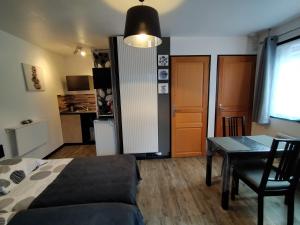 1 dormitorio con cama, mesa y cocina en Cléome, en Arques-la-Bataille