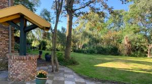 a garden with a brick pavilion and a lawn at B&B De Hooiberg Edam-Volendam in Edam