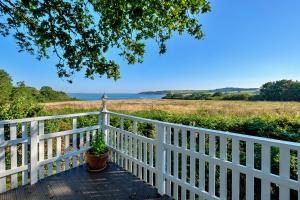 eine Veranda mit einem weißen Zaun und einer Pflanze in der Unterkunft Finest Retreats - Ocean View in Porchfield