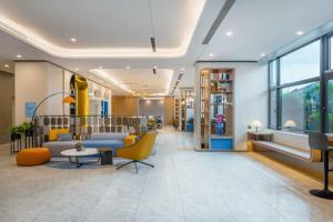a lobby of a store with yellow chairs and tables at Holiday Inn Express Jiangmen East Station, an IHG Hotel in Jiangmen