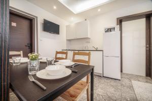 a kitchen with a dining table and a white refrigerator at Apartments By Pyramid: Elisabeth in Bratislava