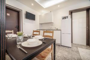 uma cozinha com uma mesa de jantar e um frigorífico branco em Apartments By Pyramid: Elisabeth em Bratislava