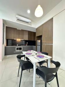 a kitchen with a white table and black chairs at A1601 Grand Medini 2BR 100mbps Netflix By STAY in Nusajaya