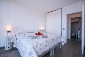 Dormitorio blanco con cama blanca y espejo en Sant' Andrea Giardino, en Menaggio