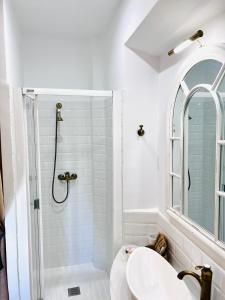 a white bathroom with a shower and a sink at Hotelito Suecia in Granada