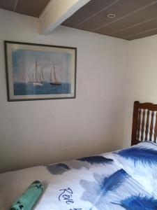 a bedroom with a bed with a painting of sailboats at Maison détente CARRY-LE-ROUET in Carry-le-Rouet
