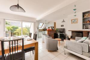 Un comedor y una sala de estar con mesa y sillas. en Vacances tout confort à Sarzeau, en Sarzeau
