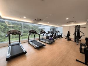 a gym with a row of treadles in a room at KASOTA SUITE Aeropod Sovo-Near KKCity-Near Airport in Tanjong Aru
