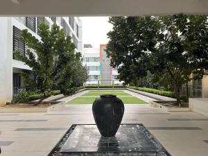 a black vase sitting on a fountain in a courtyard at KASOTA SUITE Aeropod Sovo-Near KKCity-Near Airport in Tanjong Aru
