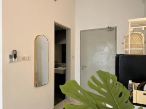 a bathroom with a mirror and a door with a plant at KASOTA SUITE Aeropod Sovo-Near KKCity-Near Airport in Tanjong Aru