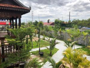 un giardino con palme e un edificio di Apsara Khmer House a Siem Reap