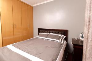 a bedroom with a bed and wooden cabinets at Cossy homes in Nakuru
