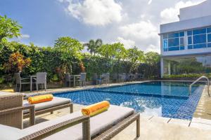 einen Pool mit Stühlen und ein Gebäude in der Unterkunft Solaris Hotel Malang in Malang