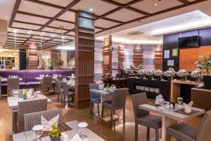 a restaurant with tables and chairs and a bar at Solaris Hotel Malang in Malang