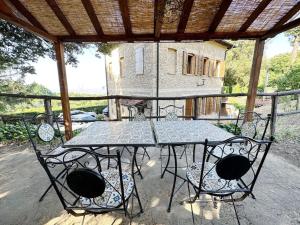 a glass table and chairs on a patio at Casale di Valle Mora in San Gimignano