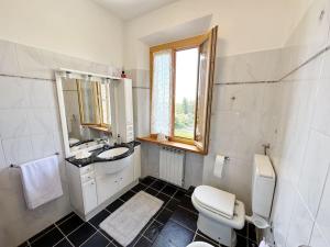 a bathroom with a toilet and a sink and a mirror at Casale di Valle Mora in San Gimignano