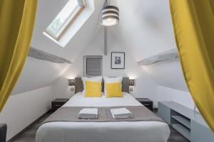 - une chambre avec un grand lit et des oreillers jaunes dans l'établissement Chambres d'hôte - Clos d'Allonne, à Beauvais