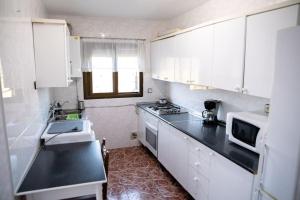 a kitchen with white cabinets and a black counter top at Casa céntrica con vistas a la sierra in Hornachuelos