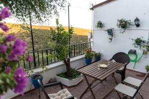 een patio met een tafel en stoelen op een balkon bij Casa céntrica con vistas a la sierra in Hornachuelos