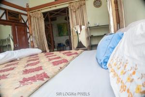 a bedroom with a bed with a quilt on it at Art and Leisure-EB Hotel in Takoradi