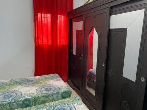 sypialnia z łóżkiem i szafką z czerwonymi zasłonami w obiekcie Karim DUPLEX w mieście Nabul