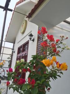 a building with a clock and flowers in front of it at SEVEN HOMESTAY(HUE) in Hue