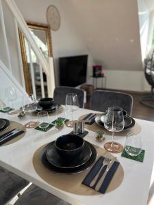 einen Tisch mit Tellern und Weingläsern darauf in der Unterkunft Moderne Galerie-Wohnung! Zentral-A8-B17 WIFI in Gersthofen