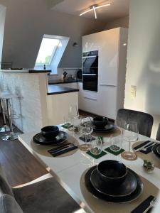 einen Esstisch mit Tellern und Weingläsern in der Unterkunft Moderne Galerie-Wohnung! Zentral-A8-B17 WIFI in Gersthofen