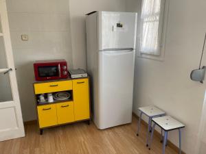 eine Küche mit einem Kühlschrank und einer Mikrowelle auf dem Tisch in der Unterkunft Piso junto universidad y Hospital Clínico in Saragossa