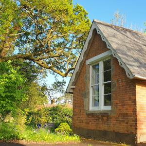 Una casa de ladrillo con una ventana en el costado. en Janitor's Lodge en Ticehurst