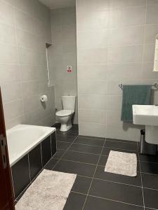 Un baño con bañera, inodoro y lavabo. en Mensija, en San Julián 7 fotos más