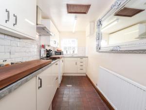 a kitchen with white cabinets and a tile floor at Ann Tysons House in Ambleside