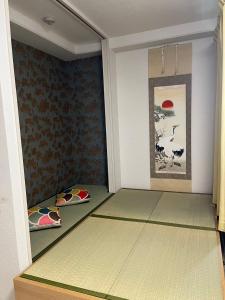a room with green flooring and paintings on the walls at 大阪旅・四葉　 in Osaka