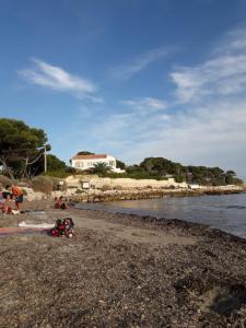 a group of people on a beach near the water at Maison détente CARRY-LE-ROUET in Carry-le-Rouet