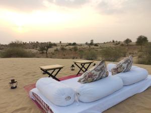 a bed on the sand in the desert at Dhora Desert Resort, Signature collection by Eight Continents in Shaitrāwa