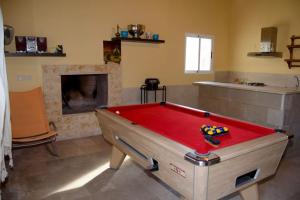 a room with a pool table in front of a fireplace at Villa en la Vega del pueblo in Cantoria