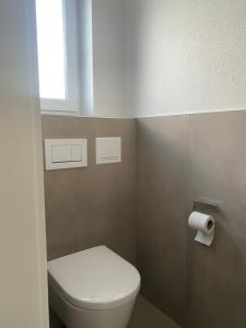 a bathroom with a white toilet and a window at Modern Living Regensburg in Regensburg +11 photos