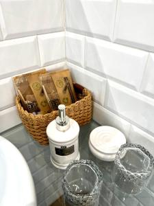 a bathroom counter with a soap dispenser and a basket at Hotelito Suecia in Granada