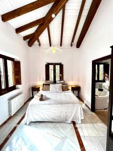 a white bedroom with a bed and a bathroom at Hotelito Suecia in Granada