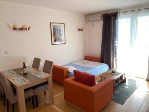 ein Wohnzimmer mit einem Bett, einem Tisch und Stühlen in der Unterkunft BLUE EYES SAILORS in Kotor