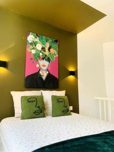 a bedroom with a bed with a painting on the wall at L'escale Béthunoise - Maison duplex, hyper-centre in Béthune