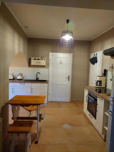 a kitchen with white cabinets and a table in it at NEU! Ferienwohnung Böhlitz Neun in Grimma
