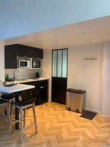 a kitchen with a wooden floor and a table with chairs at L'escale Béthunoise - Maison duplex, hyper-centre in Béthune +18 photos