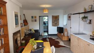 a living room with a table and a tv in it at Janitor's Lodge in Ticehurst